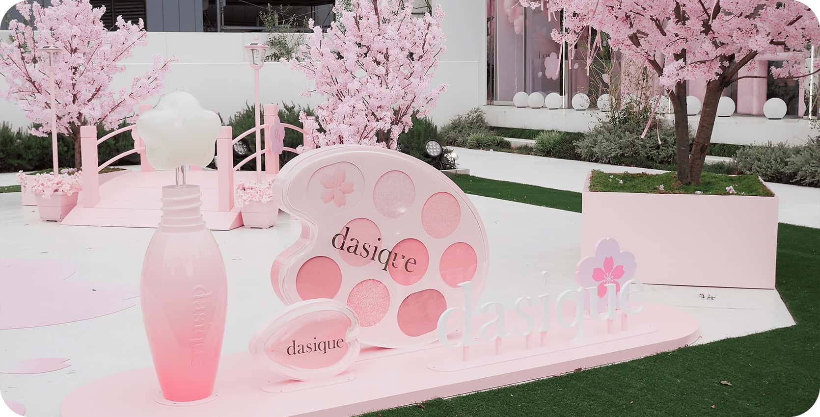Instalación pop-up exterior de la marca Dasique con temática de flores de cerezo rosa, un ejemplo de estrategias de comunicación visual para captar la atención de los consumidores.